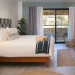 King bed, chairs in Hideaway room with view of private balcony through sliding doors